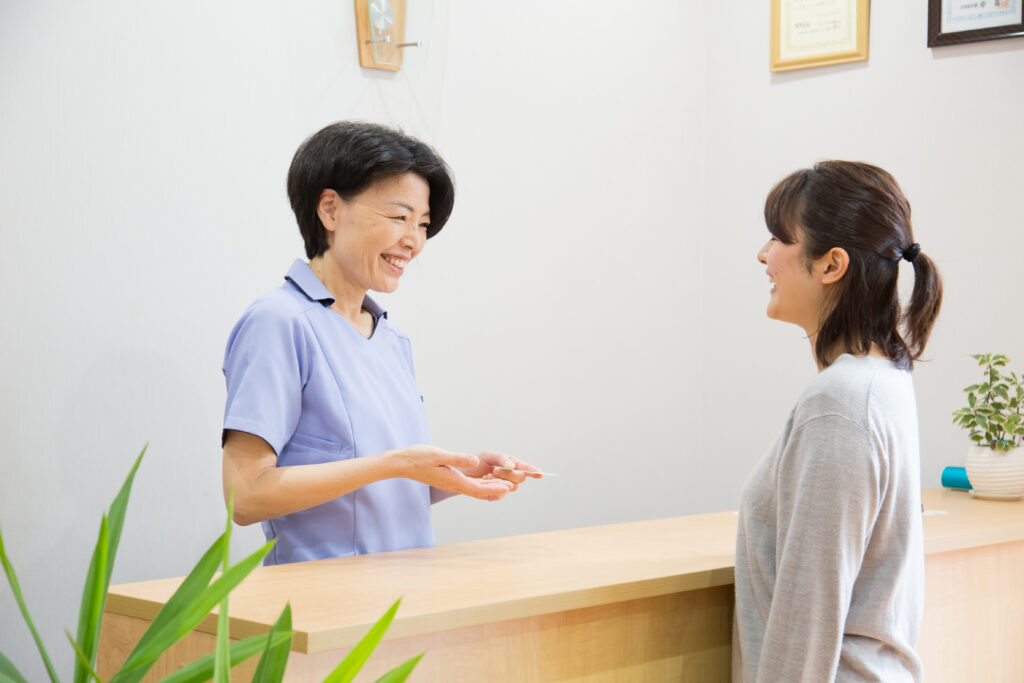 受付で来院者へ案内するスタッフ|山下針灸房(姫路市 妊活・マタニティ鍼灸)